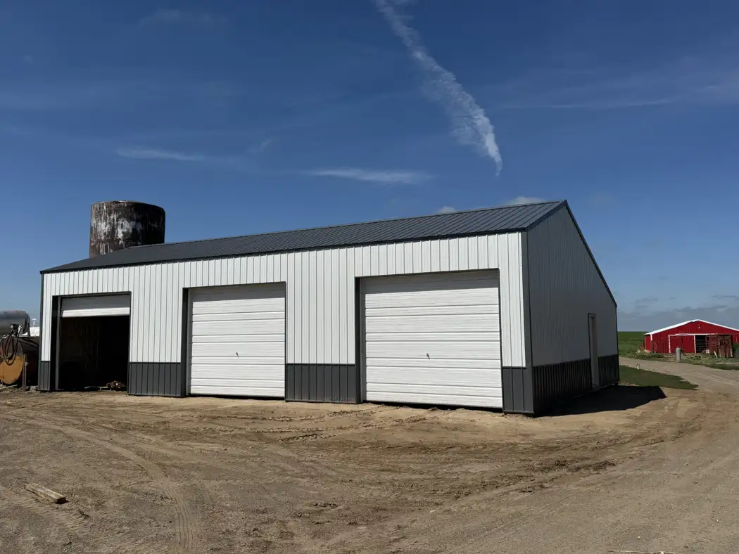 A second front view shows the completed roof, wall panels, overhead doors, and contrasting trim.