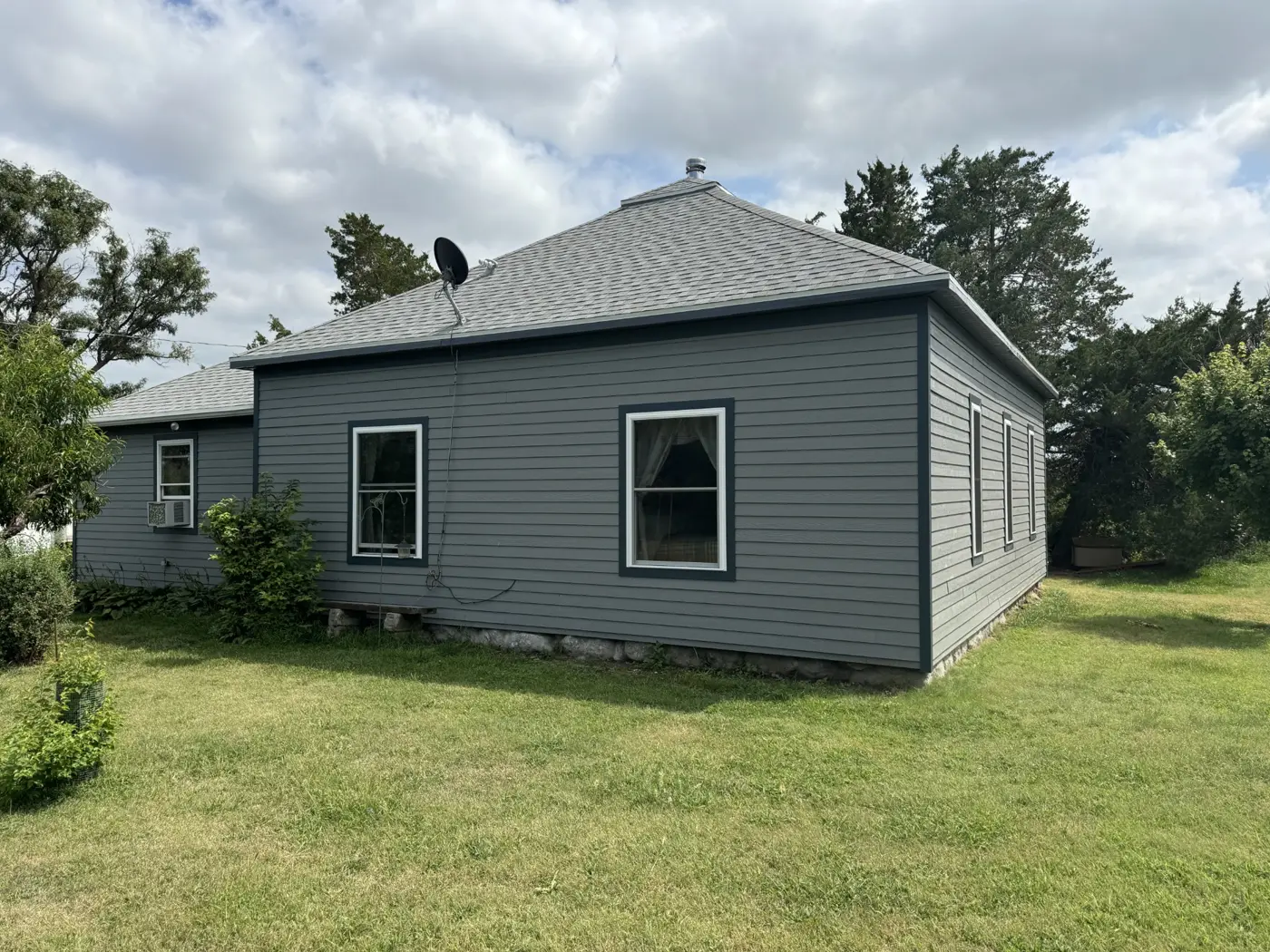 The updated exterior carries the same siding and trim treatment around the house.