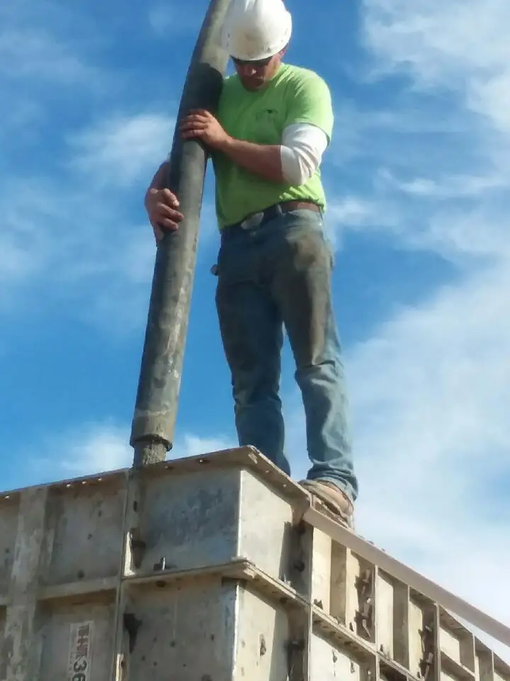 A close view of concrete placement at the top of the foundation forms.