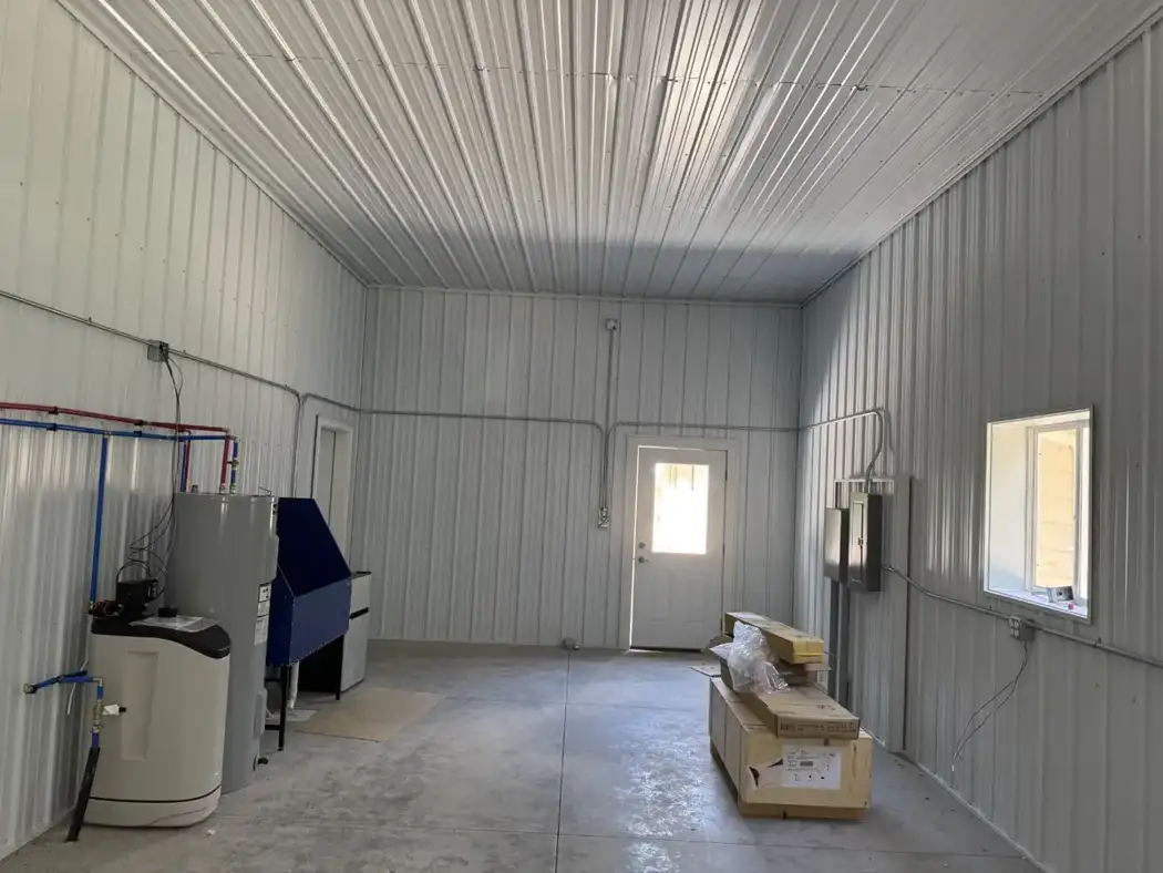 The finished interior includes an entry door, electrical service panels, plumbing, and utility equipment.