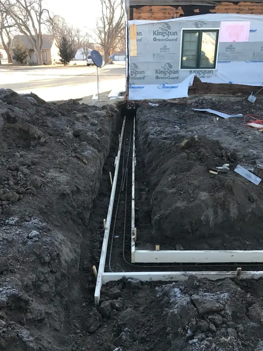 Formed footing trench beside an existing home