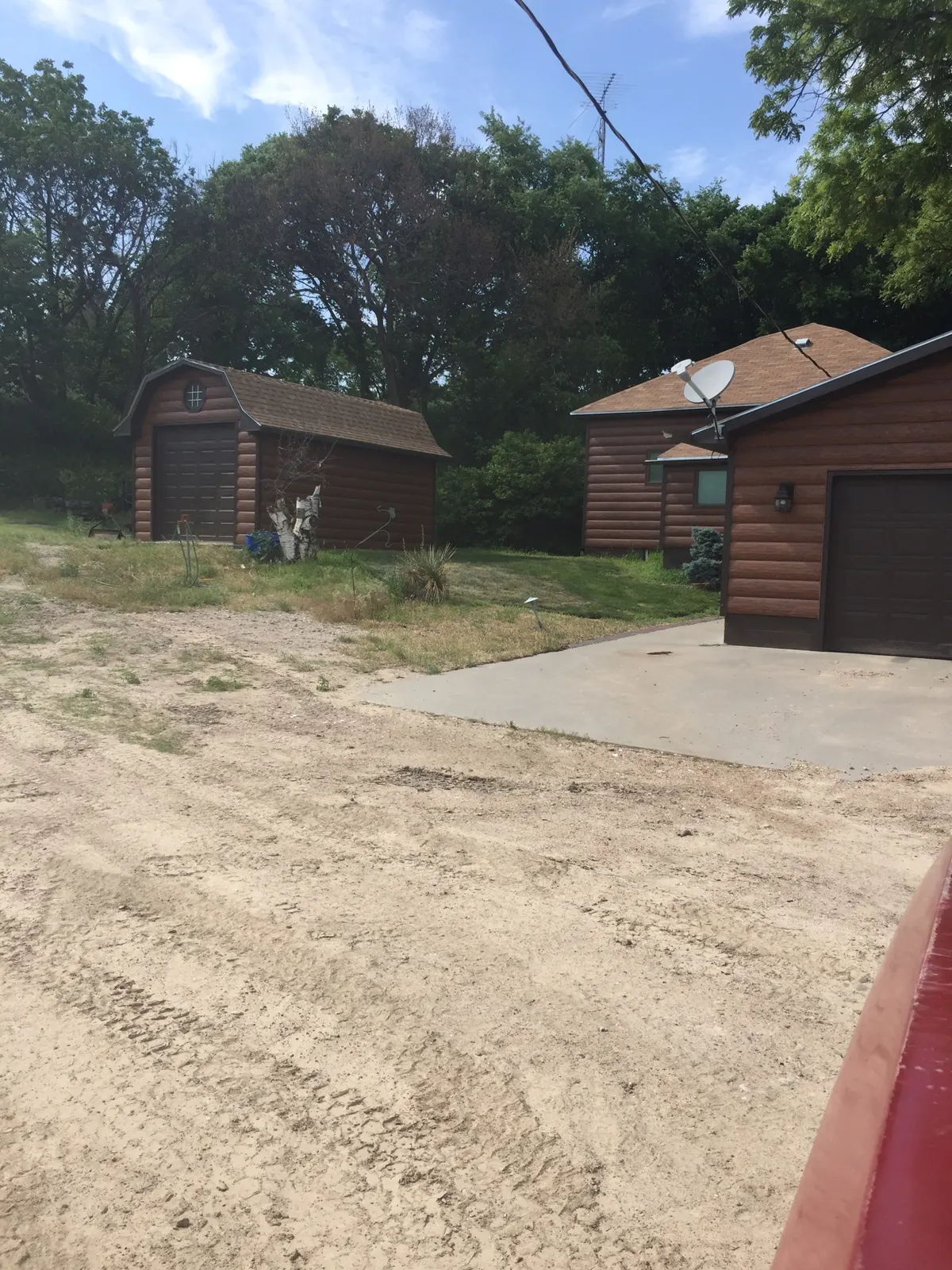 A wider view of the finished garage and outbuildings with coordinated TruLog siding and trim.