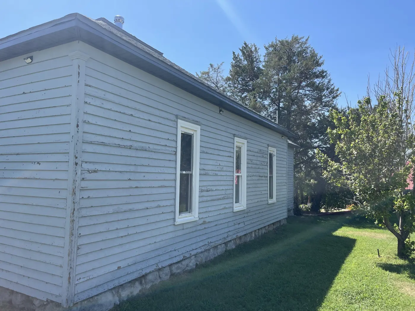 Existing siding and windows along the side of the house before renovation.