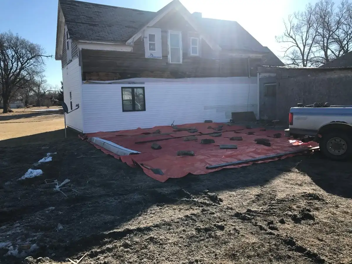 Home exterior during renovation with protected ground area