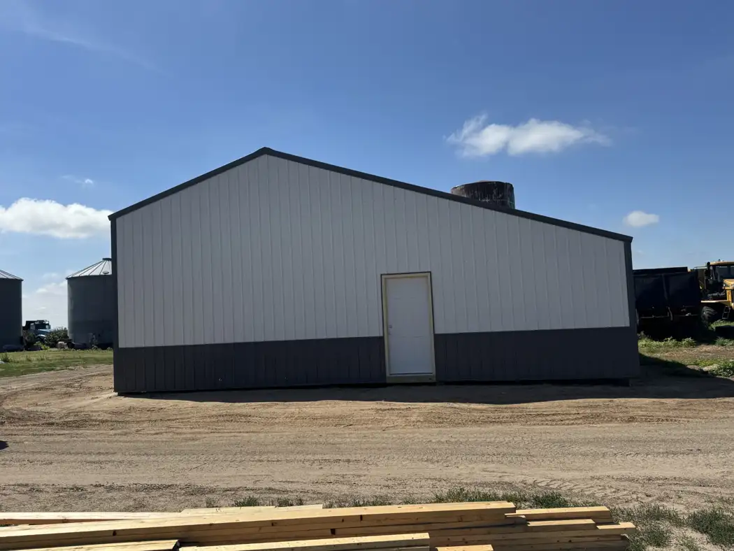 Metal siding and trim finish the end elevation, with a separate entry door for access.