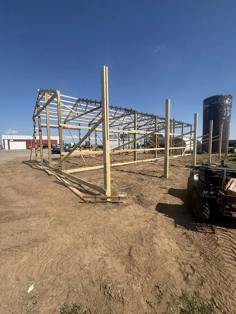 Posts and roof framing establish the main building and the attached open storage area.