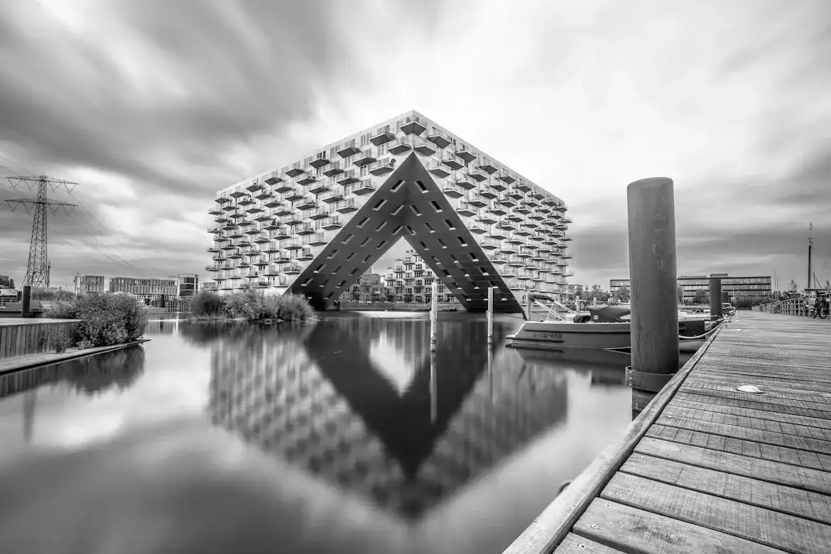 Black-and-white photograph of Sluishuis in Amsterdam reflected in the water