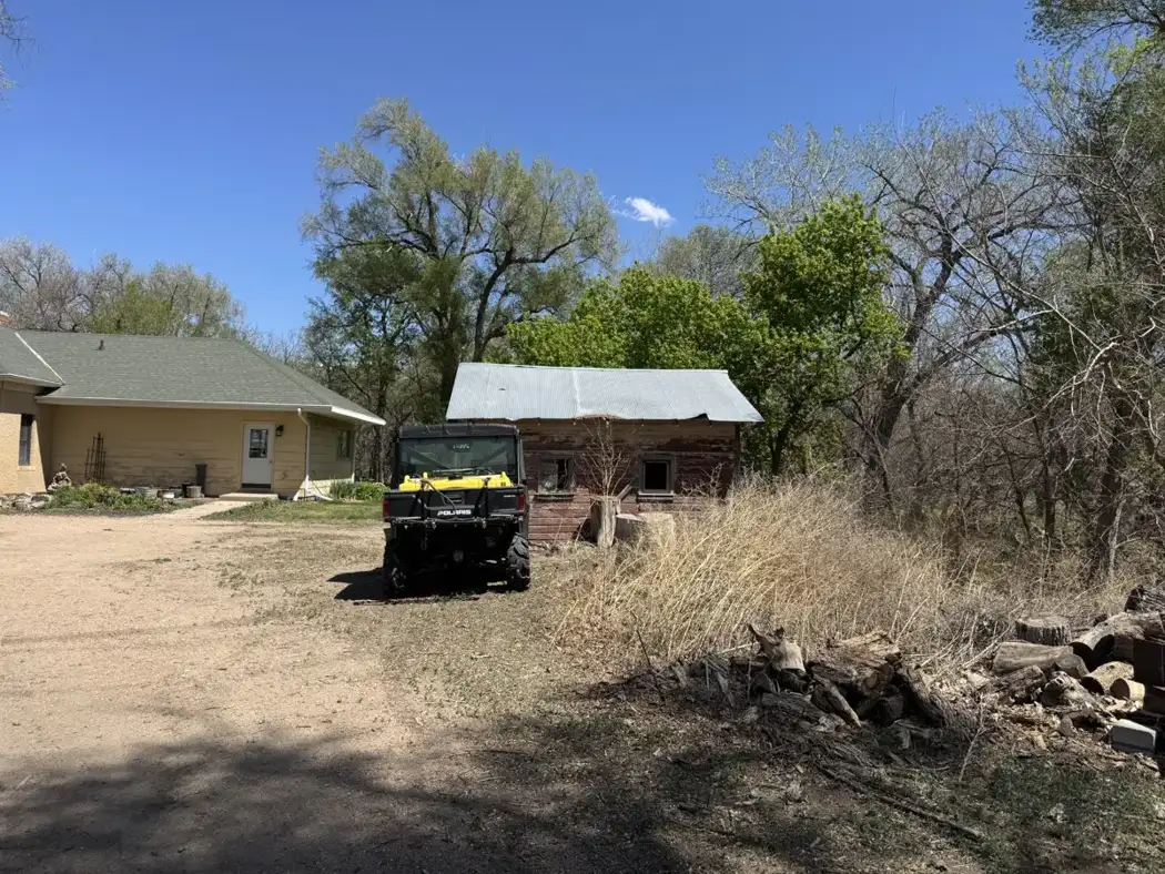 The existing outbuilding and surrounding area before site preparation for the new garage and shop.