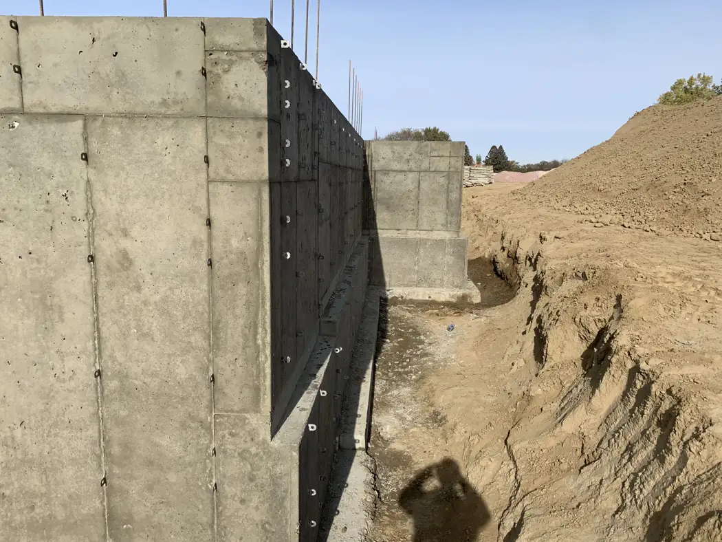 The exterior concrete wall is visible along the excavated working area.