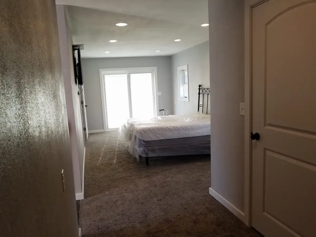 View through the finished hallway into the bedroom and patio doors