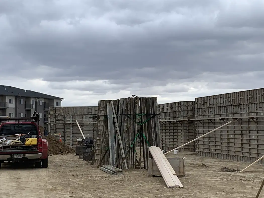 A wider view of the wall formwork and working area around the foundation.