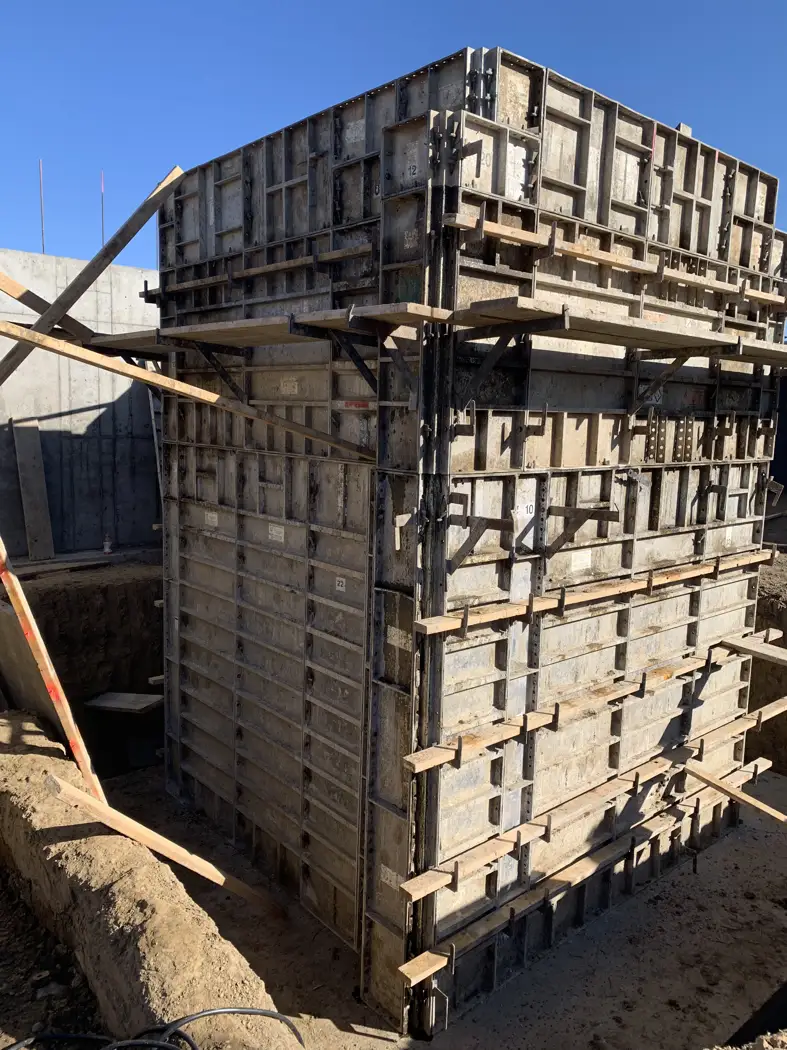Form panels and support members wrap the concrete wall corner.