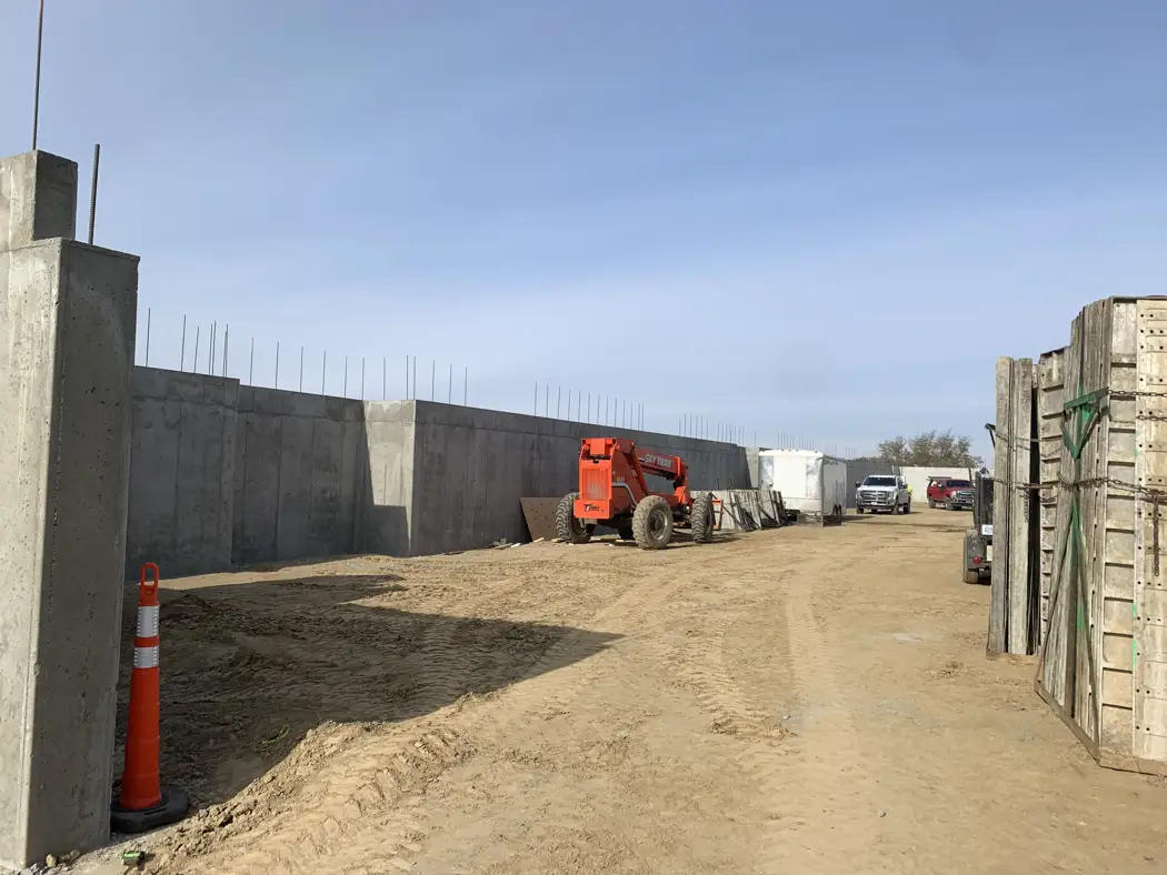 A wider view follows the exposed concrete wall line and the working area beside it.
