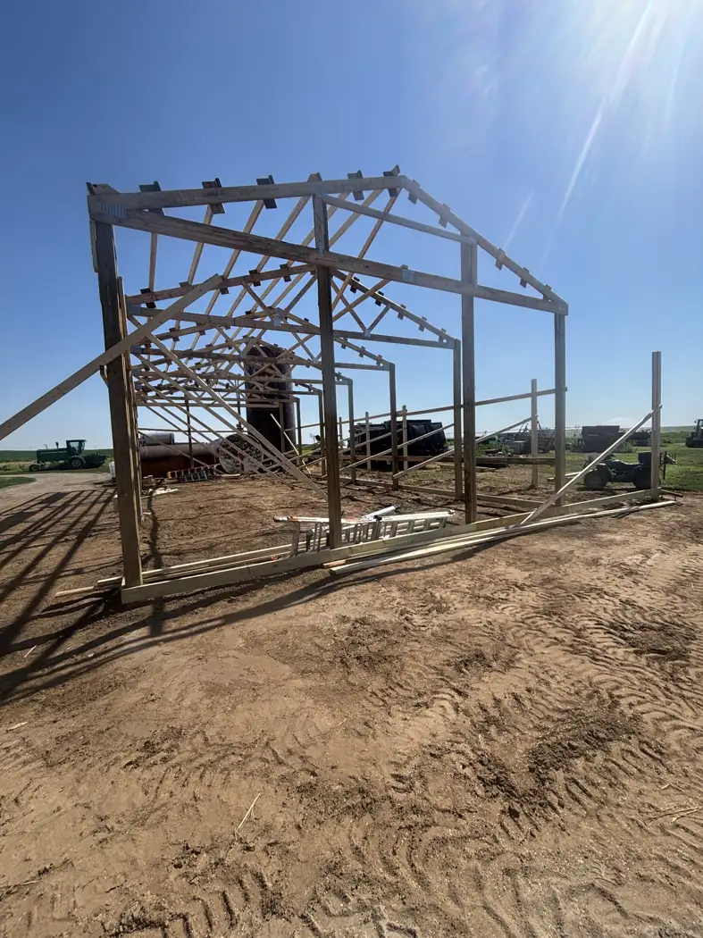 The gable-end framing and roof trusses take shape as the structure progresses.