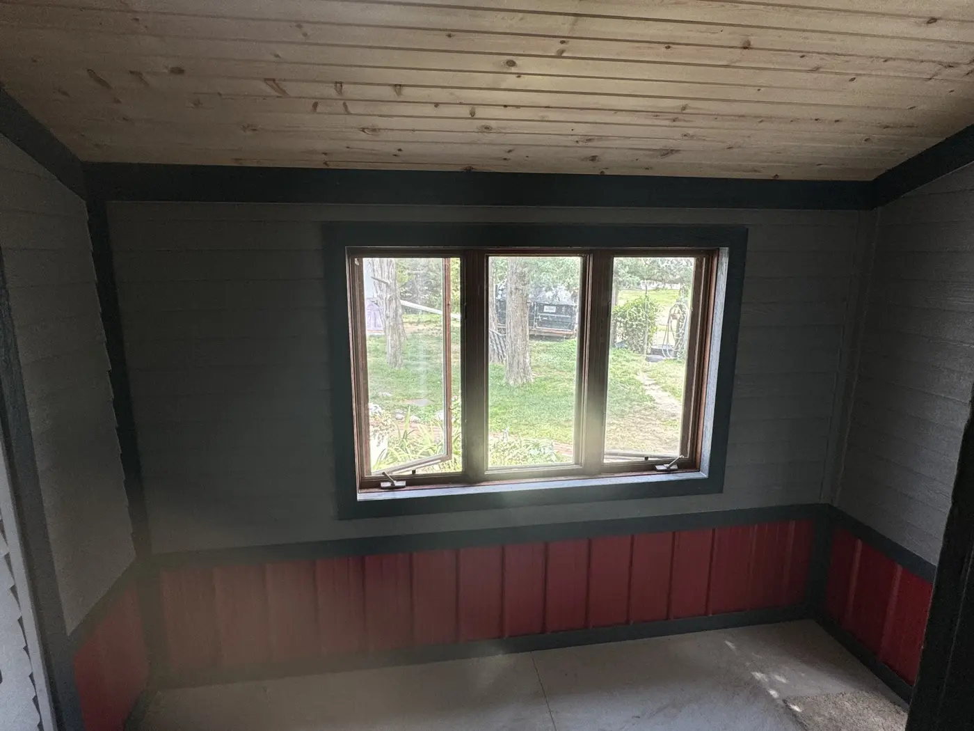 The porch addition combines natural wood overhead with contrasting wall finishes and window trim.