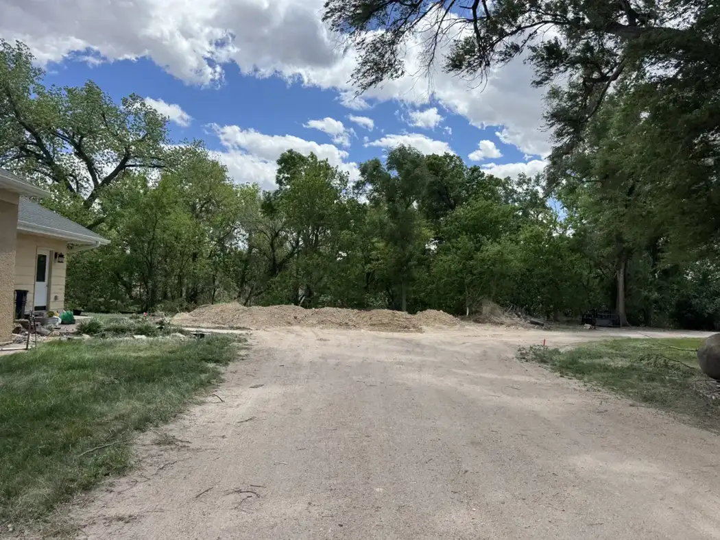 The cleared and graded area is prepared for construction access and the new building footprint.