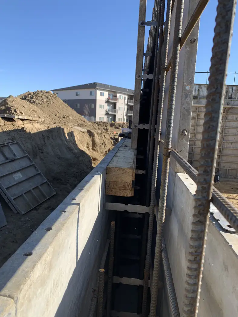 Reinforcing steel and wall forms define the concrete wall cavity.