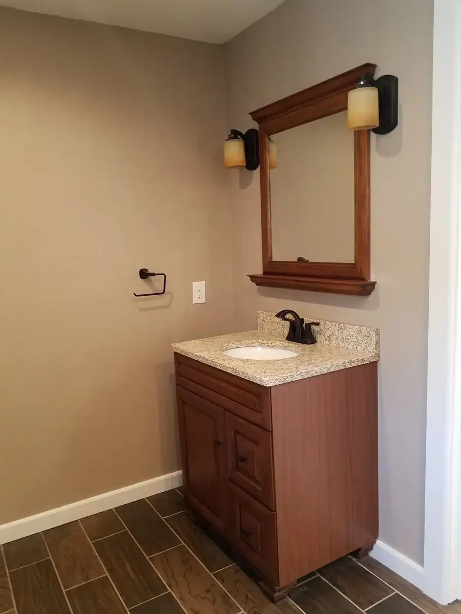 Wood vanity with countertop mirror and wall lighting