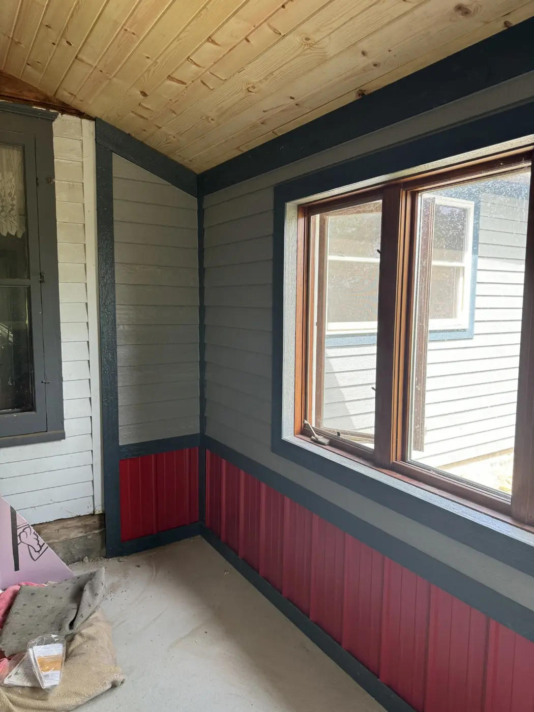 A closer view of the porch window, wall finishes, and wood ceiling.
