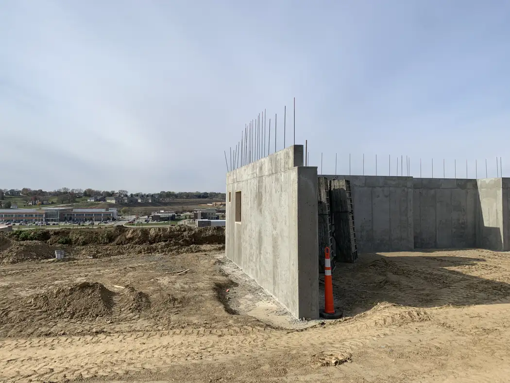 Completed wall sections retain projecting reinforcement above the concrete for the next construction stage.