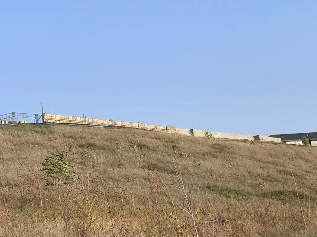 A wider view of the foundation site and completed concrete visible above the grade.