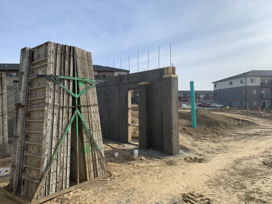 Some form panels remain supported beside newly exposed concrete walls.